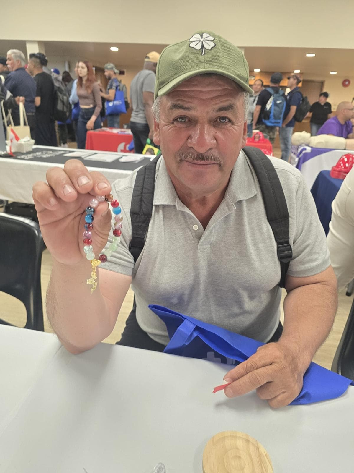 Man wearing sunglasses showing a completed bead bracelet on his wrist