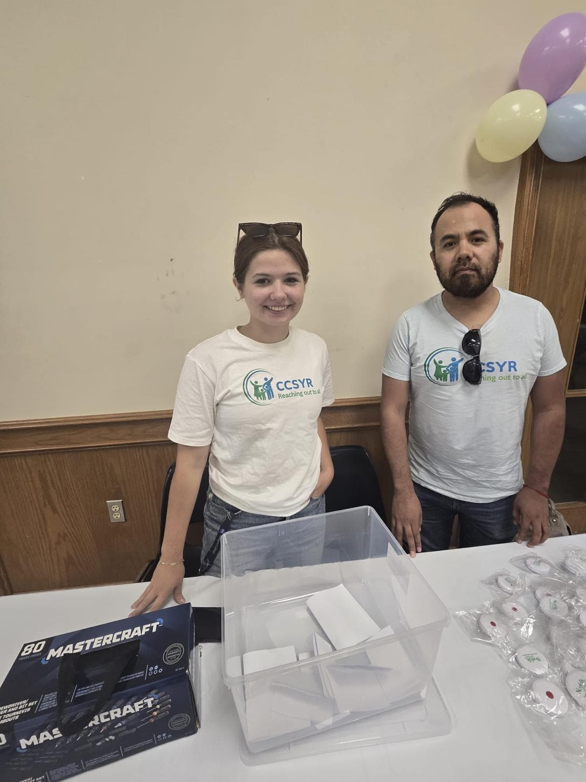 Community members and a firefighter making bead bracelets at a workshop table