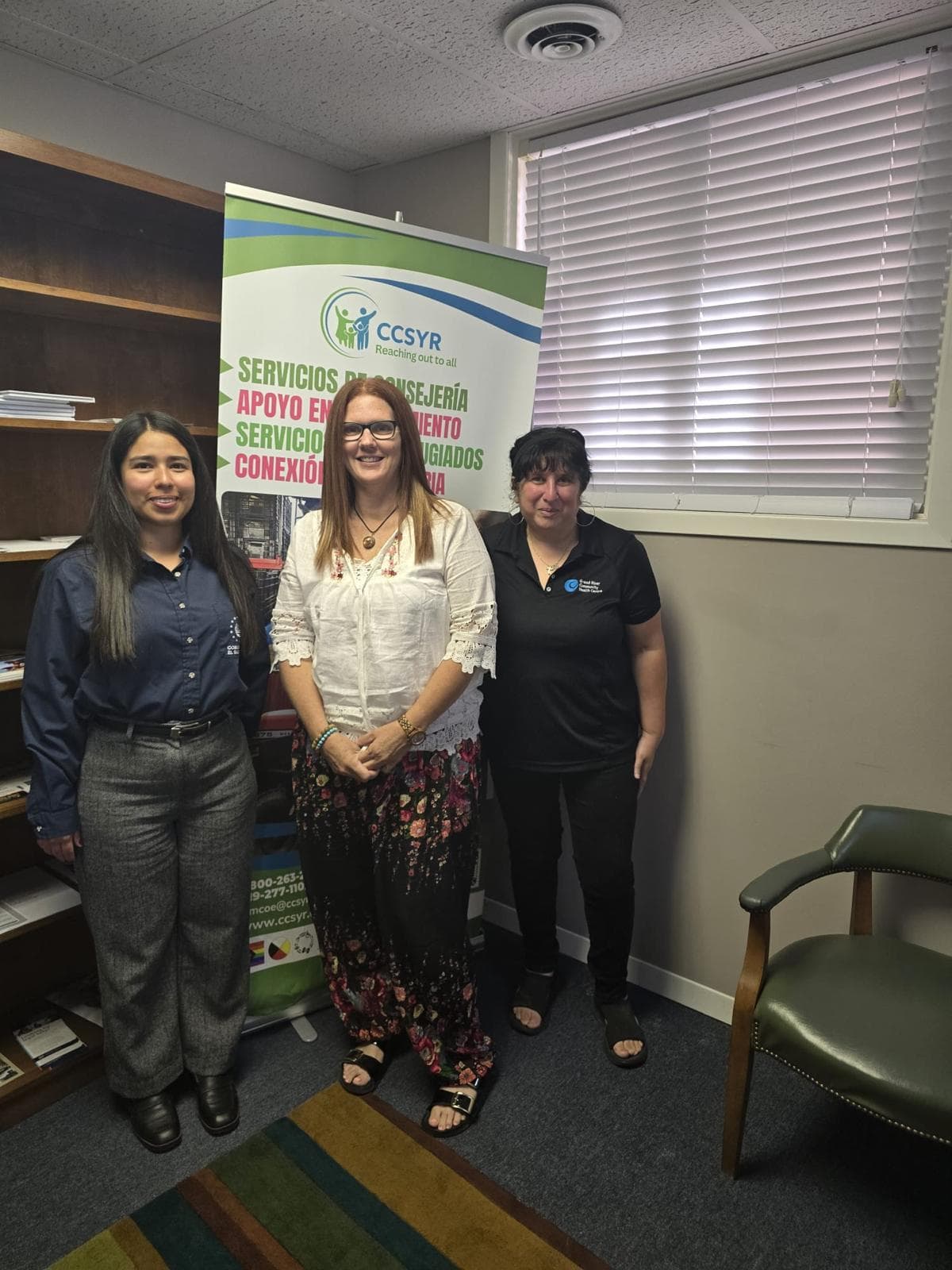 Staff members with a Spanish-language services banner
