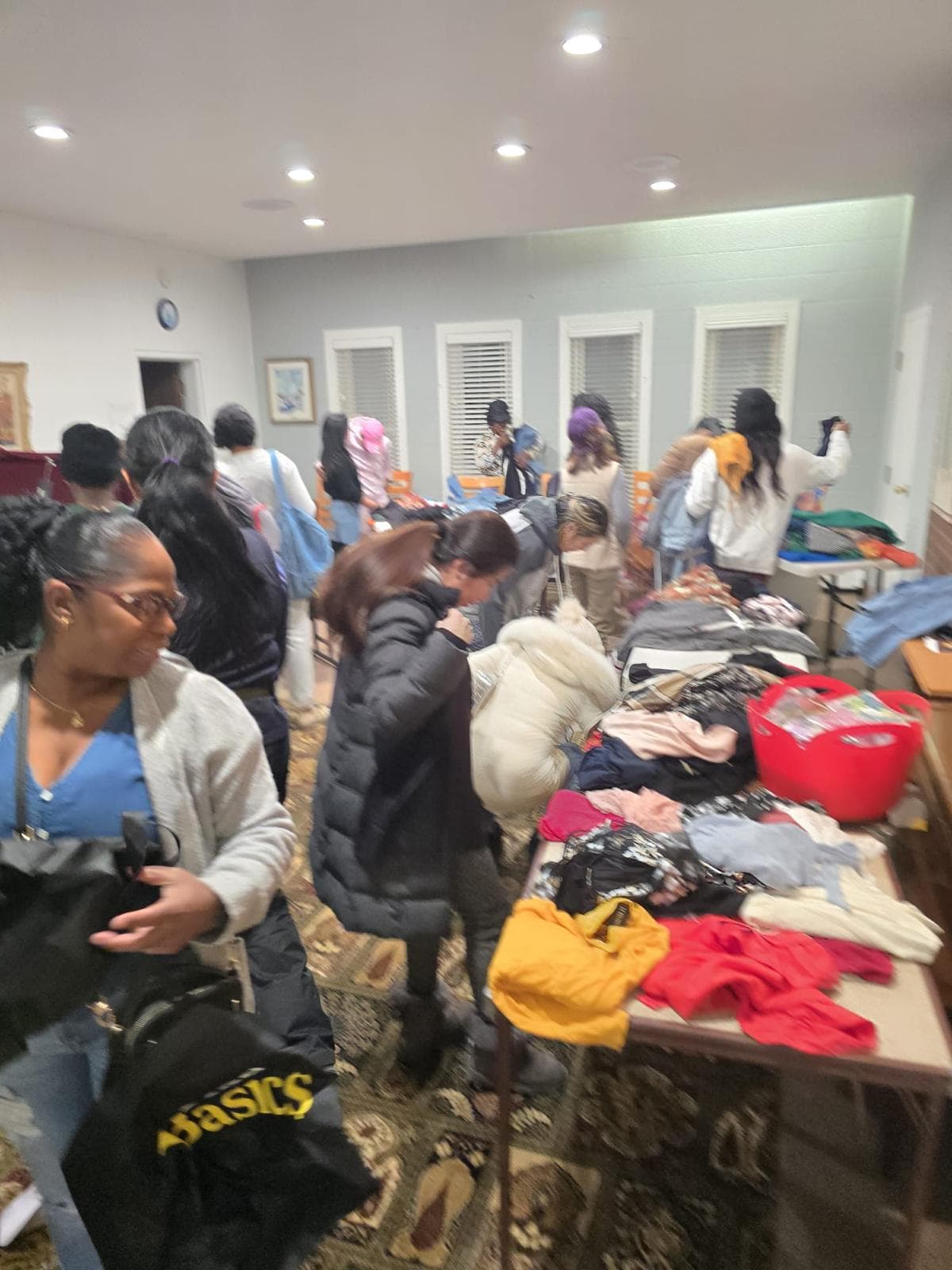 People browsing tables of donated clothes at the community clothing swap
