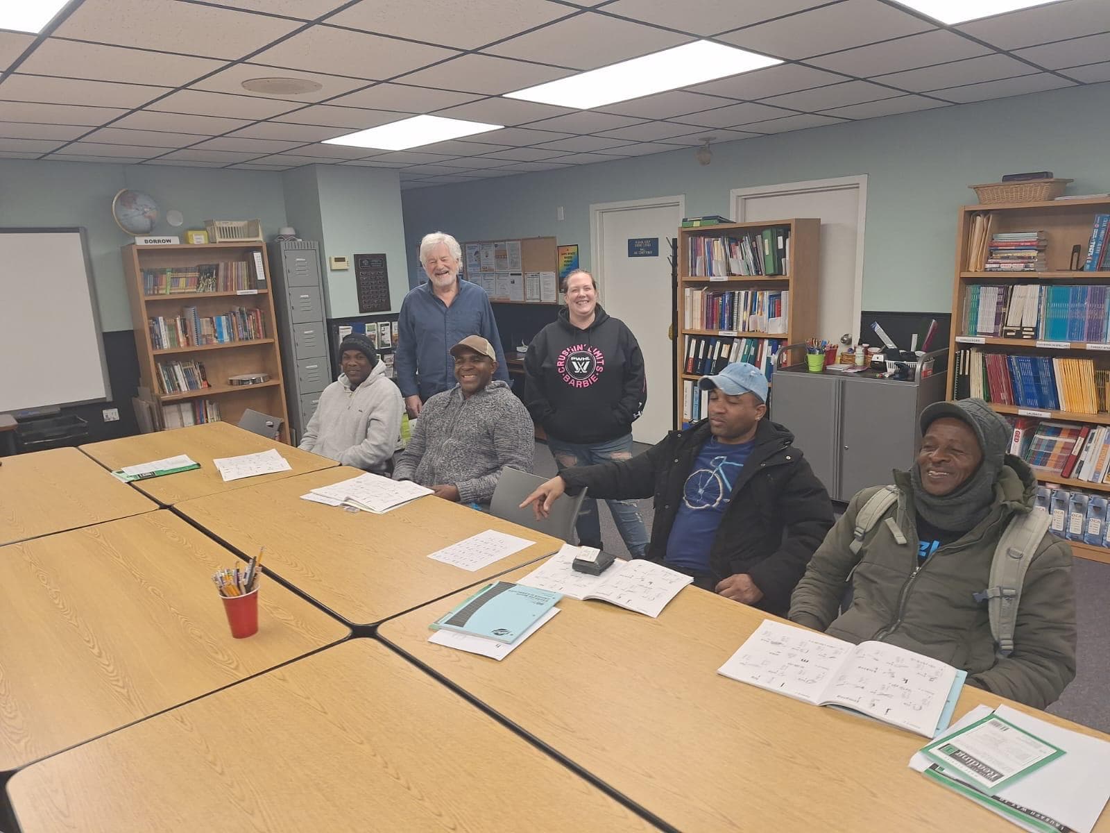 Participants in an English language class working through workbooks together