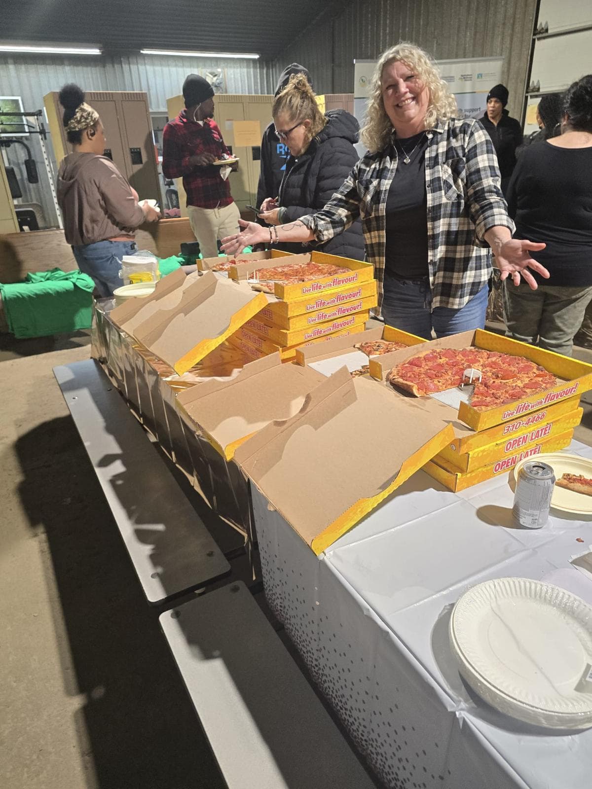Volunteer serving stacks of pizza at a barn community night