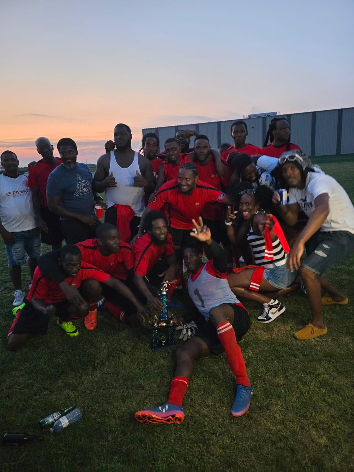 Soccer team celebrating with a trophy at sunset