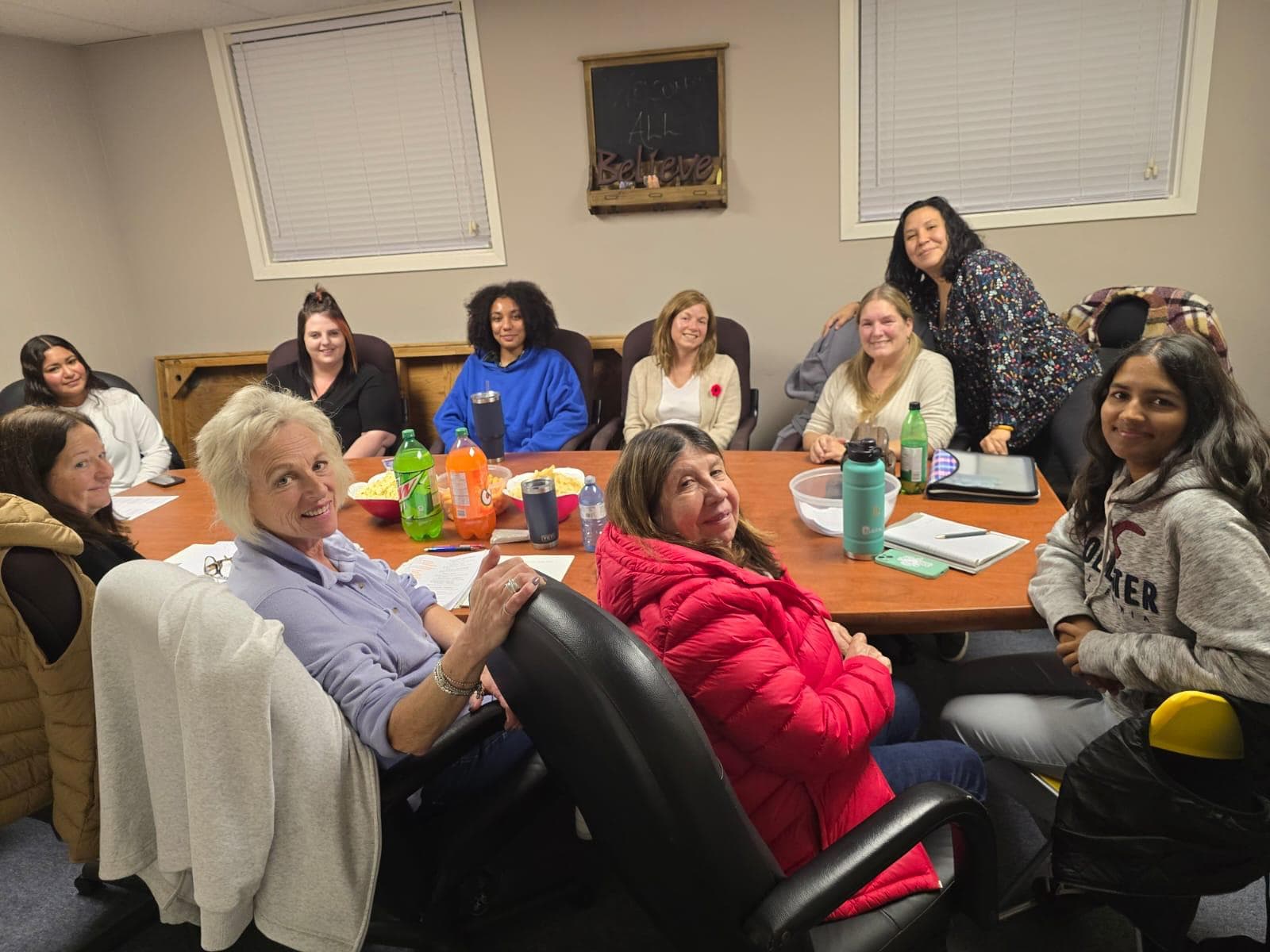 Women gathered around a conference table for a support group meeting